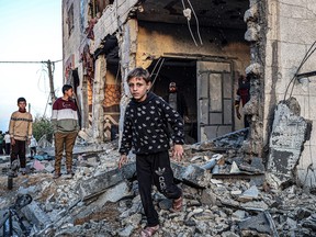 People walk through the rubble of a building heavily damaged by Israeli bombardment, in Rafah in the southern Gaza Strip on Feb. 11, 2024, amid the ongoing conflict between Israel and the Palestinian militant group Hamas.