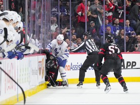Morgan Rielly, do Toronto Maple Leafs, fica sobre Ridly Greig, do Ottawa Senators, após ser cruzado na cabeça após seu gol vazio no Canadian Tire Centre em 10 de fevereiro de 2024 em Ottawa.