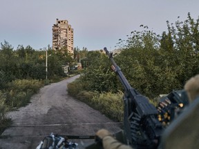 FILE - A Ukrainian soldier sits in his position in Avdiivka, Donetsk region, Ukraine, on Aug. 18, 2023. Ukrainian forces claimed Thursday, Feb. 8, 2024, to have shot down a Russian attack helicopter near the eastern Ukraine city of Avdiivka, where the sides are fighting from street to street as the Kremlin's forces step up their four-month campaign to surround Kyiv's defending troops.