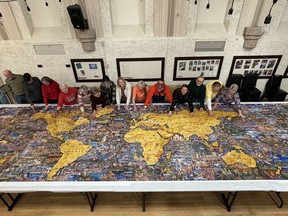 Springville Senior Center members and puzzle artist Eric Dowdle, fifth from right, with the completed 60,000-piece puzzle earlier this month. The centre is in Springville, Utah.