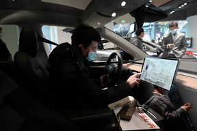 A man checks the dashboard touch screen in a Tesla Model Y car at a Tesla showroom in Beijing on Jan. 5, 2021.