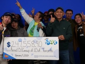 A group of 12 warehouse workers collect Lotto Max winnings.