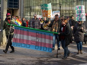 People protest against Alberta Premier Danielle Smith's proposed policy changes regarding transgender youth, at a rally in Edmonton on Sunday.