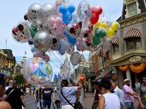 A vendor sells balloons in Walt Disney World's Magic Kingdom.