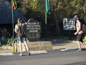 Tourists wear face masks at the entrance of the Victoria Falls