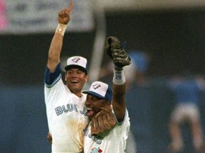 Toronto Blue Jays' Roberto Alomar (left) jumps into the arms of Joe Carter (R) after winning Game 6 of the ALCS.