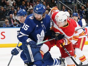 William Lagesson of the Toronto Maple Leafs and Connor Zary of the Calgary Flames battle for position.