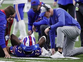An injured Buffalo Bills cornerback Tre'Davious White (27) is helped by head coach Sean McDermott, right, and medical staff.