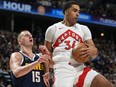 Toronto Raptors centre Jontay Porter, right, pulls in a rebound as Denver Nuggets centre Nikola Jokic defends.