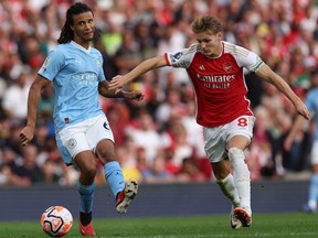 Manchester City's Nathan Ake (left) vies with Arsenal's Martin Odegaard during a game earlier this season.