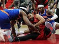 New York Knicks forward Precious Achiuwa (left) battles for the ball with Toronto Raptors forward Garrett Temple as Knicks guard Miles McBride looks on.