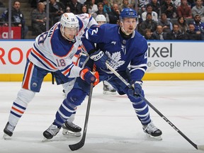 Zach Hyman of the Edmonton Oilers skates against Simon Benoit of the Toronto Maple Leafs during a game.