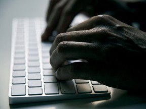 Man typing on a computer keyboard.