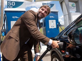 Environment Minister Minister Steven Guilbeault plugs in an electric car at a news conference in Laval, Que., in 2021.