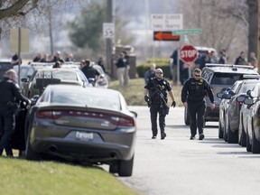 Law enforcement officials and medical personnel work the scene of an officer involved shooting near the intersection of Elsea Smith Road and Budschu Road on Thursday, Feb. 29, 2024, in Independence, Mo. (Nick Wagner/The Kansas City Star via AP)