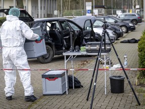 A forensics officer works near a car in front of the Von D'ring barracks in Rotenburg, Germany, Friday March 1, 2024 after four people were killed in shootings in northern Germany. (Sina Schuldt/dpa via AP)