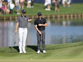 Jordan Spieth of the United States and Rory McIlroy of Northern Ireland look on from the 16th green.