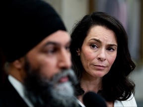 Heather McPherson looks on as NDP Leader Jagmeet Singh speaks to reporters.
