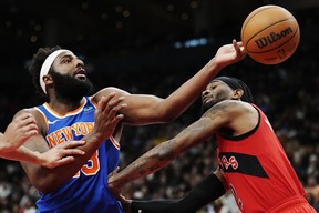New York Knicks' Mitchell Robinson (left) battles for a rebound with Raptors forward Jalen McDaniels' during the second half in Toronto on Wednesday, March 27, 2024.