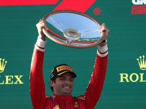 Ferrari's Spanish driver Carlos Sainz Jr celebrates with the trophy on the podium after the Australian Formula One Grand Prix at Albert Park Circuit in Melbourne on March 24, 2024.