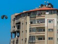 A parachute falls behind a building as aid parcels are airdropped