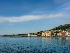 Ancient Kilitbahir Castle on the seashore under clear blue skies with scattered white clouds, Eceabat, Canakkale, Turkey