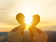 Two hands and a broken heart on a sunset background.