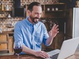 Smiling man having video chat with somebody on laptop.