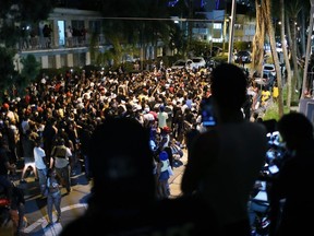 People gather while exiting the area as an 8pm curfew goes into effect on March 21, 2021 in Miami Beach, Florida.