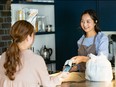 Woman paying for takeout order at restaurant.