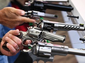 Tight shot of several revolver pistols being held