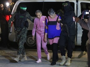 Hamas and Islamic Jihad fighters accompany newly released Israeli hostages, held since the Oct. 7 attacks, before handing them over to the Red Cross in Rafah, in the southern Gaza Strip on Nov. 28, 2023.