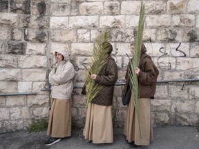 Christians walk in the Palm Sunday procession on the Mount of Olives in east Jerusalem, Sunday, March 24, 2024.