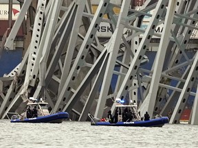 Police boats work around a cargo ship