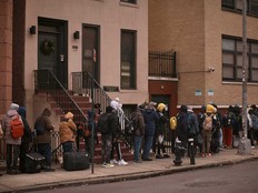 Migrants queue in the cold as they look for a shelter outside a migrant assistance center at St. Brigid Elementary School, Dec. 5, 2023, in New York.