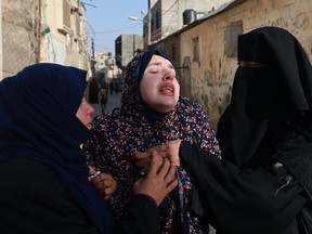 Rania Abu Anza (centre) the mother of twin babies Naeem and Wissam, killed in an overnight Israeli air strike, mourns their death ahead of their burial in Rafah in the southern Gaza Strip on March 3, 2024, as the conflict between Israel and the Palestinian militant group Hamas continues.