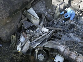 The wreckage off a bus lays in a ravine