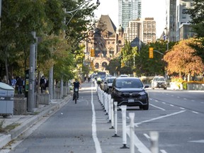 A cyclist rides on the bike lane along University Ave. in downtown Toronto on Wednesday, Oct. 5, 2022.