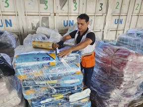 A United Nations worker prepares aid for distribution to Palestinians at UNRWA warehouse in Deir Al-Balah, Gaza Strip, on Monday, Oct. 23, 2023.