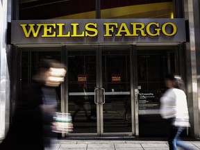 In this Oct. 6, 2016 file photo, pedestrians walk past a Wells Fargo bank branch in New York.