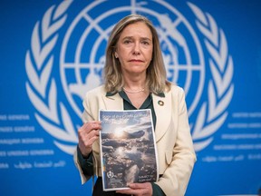 World Meteorological Organization (WMO) Secretary-General Celeste Saulo poses with the WMO's 2023 global climate report prior to a press conference in Geneva, on March 19, 2024.