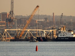 A crane works on the debris of the Francis Scott Key Bridge