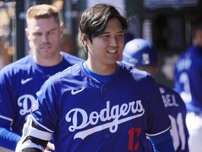 Los Angeles Dodgers' Shohei Ohtani, of Japan, walks through the dugout during the team's spring training baseball game against the Seattle Mariner, March 13, 2024, in Phoenix. Beginning with its ninth international opener, Major League Baseball is traveling all over the world in 2024. Ohtani and the Dodgers play Manny Machado and the San Diego Padres in Seoul, South Korea