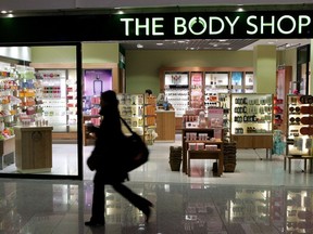 A woman passes a Body Shop cosmetics store.