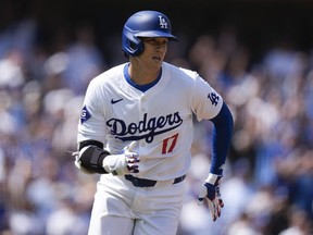 Los Angeles Dodgers' Shohei Ohtani runs to first base after hitting a double against the St. Louis Cardinals during the first inning of a baseball game Thursday, March 28, 2024, in Los Angeles.