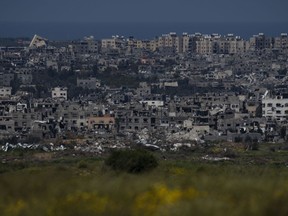 Destroyed buildings stand in the Gaza Strip, as seen from southern Israel, Wednesday, March 20, 2024. The federal government says people who managed to escape the Gaza Strip no longer qualify for a special program to reunite with extended family members in Canada if they didn't finish the application process before they left.