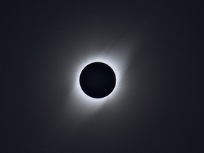 The sun's atmosphere, or corona, appears behind the moon