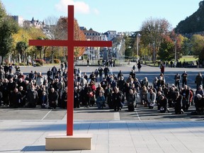 FILE - Bishops kneel on the forecourt of the Notre-Dame-du-Rosaire basilica in the sanctuary of Lourdes, southwestern France, Saturday, Nov. 6, 2021. More than 500 victims of child sexual abuse by priests or other church representatives have received financial compensation from France's Catholic Church under a sweeping reparations program, the independent body in charge of the process said Thursday March 14, 2024.