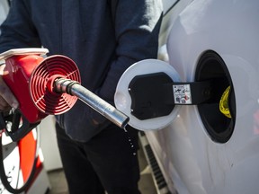 A man prepares to pump gas in Toronto, on April 1, 2019.