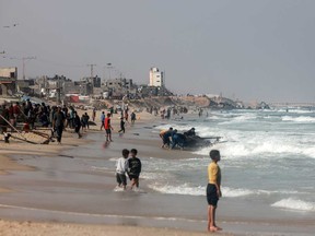 Palestinians gather along a beach adjoining a makeshift camp for displaced people in Rafah in the southern Gaza Strip on March 30, 2024, amid the ongoing conflict between Israel and the militant group Hamas.